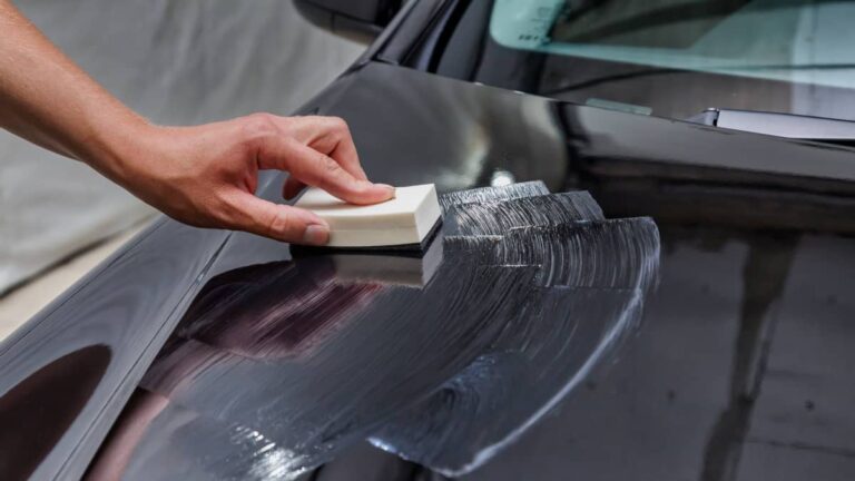 Professional Ceramic Coating Specialist Applying Protective Coating on Black Tesla Model Hood for a High-Gloss Finish and Enhanced Durability